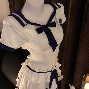 Detailed view of navy blue sailor collar and embroidered crest on white school uniform top