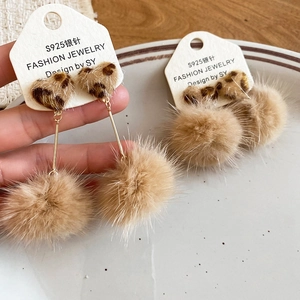 Detail of leopard print heart earrings with beige plush pompom and S925 silver needle