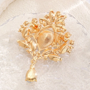 Detailed back view of vintage gold flower brooch showing safety pin clasp and metal texture
