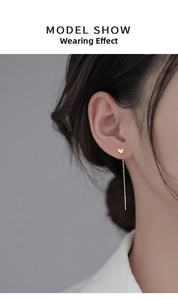 Model wearing elegant s925 gold heart long tassel ear line showing light dangling effect