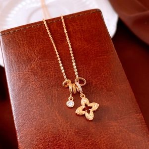 Dettaglio della collana con ciondolo a fiore dorato e zircone su sfondo in pelle