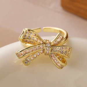 Luxurious gold bow ring with sparkling zircon stones in a minimalist open design