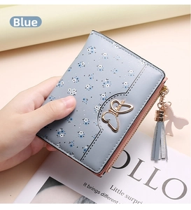 Detail of light blue floral short wallet with gold butterfly charm and tassel zipper