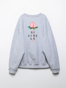 Détail du dos du sweat gris avec motif de pêche rose et impression XI XING LE