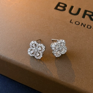 Macro detail of silver four-leaf clover stud earrings with sparkling zircon gemstones