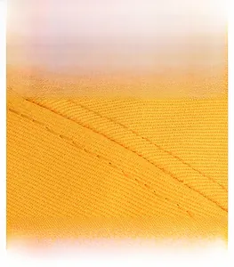 Macro detail of yellow cotton fabric with precise double stitching on baseball cap brim