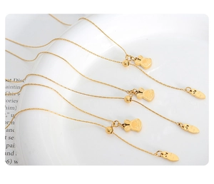 Detailed view of gold rabbit pendants with carrot charms on dainty stainless steel chains
