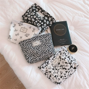 Detailed flat lay of floral bubble cotton pouches with zipper and woven party labels