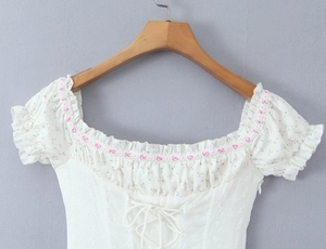 Détails du haut blanc vintage avec bordure en dentelle florale et cordon de serrage