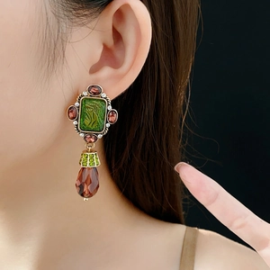 Vintage style earring with green portrait relief and a reddish-brown teardrop pendant