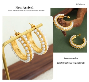 Detailed view of vintage gold plated C-shaped earrings with pearl pave inlays