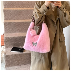 Pink faux fur handbag detail with silver butterfly charm and matching plush pompom