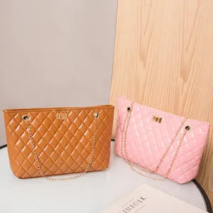 Quilted tote bags with chain straps in brown and pink PU leather on a white table
