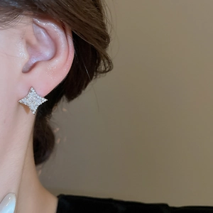 Macro close-up of sparkling silver star stud earrings with micro-pave cubic zirconia crystals