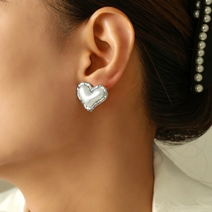 French vintage heart pearl earrings with textured silver metal frame on model