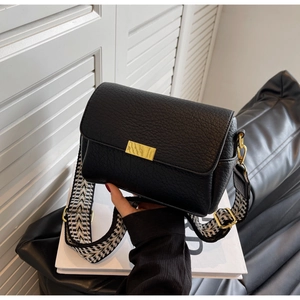 Détail du sac à bandoulière en cuir noir avec sangle géométrique et boucles dorées