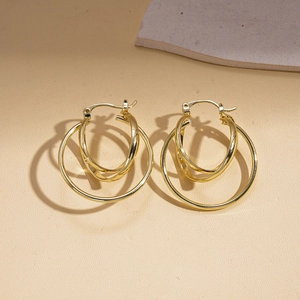 Detail showing three interlocking golden metal geometric rings with a polished finish