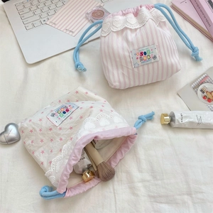 Detail of lace-trimmed drawstring storage bags showing cotton texture and storage capacity