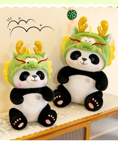 Detail van twee schattige panda pluche dieren met groene drakenkappen op tafel