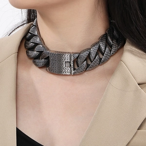 Macro shot of silver chunky Cuban chain necklace with detailed braided texture on model