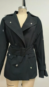 Détail d'une robe blazer noire avec ceinture à boucle métallique et accents argentés