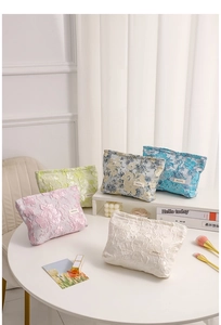 Floral jacquard makeup bags in pink, green, and blue shown in a lifestyle setting