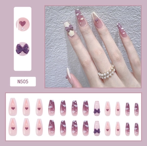 Detail of purple ballerina press-on nails with 3D bows, hearts and pearl decorations