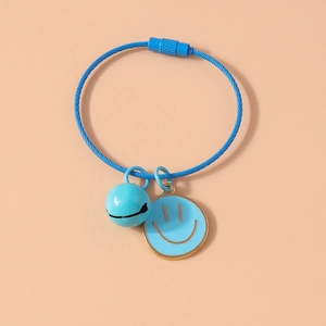 Detailed view of blue woven bracelet with smiley face pendant and golden bell