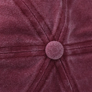 Close-up of the vintage burgundy baseball cap top button and detailed six-panel stitching