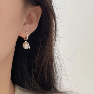 Close-up of 925 sterling silver pearl earrings with polished finish on model
