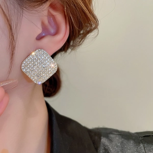 Macro detail of geometric square stud earrings with pave setting and sparkling rhinestones