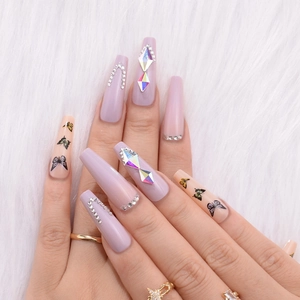 Detailed view of long ballerina press-on nails with butterfly decals and rhinestones