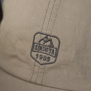 Front view of khaki cotton baseball cap with mountain embroidery and SIWDOYA 1985 text