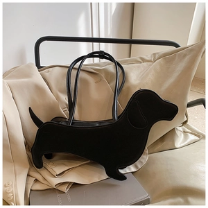 Detailed close-up of a black dachshund-shaped shoulder bag on a beige wool coat