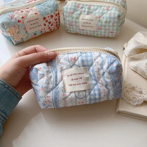 Detail of floral and checkered quilted cotton cosmetic bag with French woven label