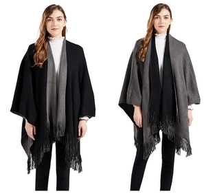 Detailed view showing the reversible black and grey knit design of the tassel cape poncho