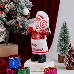 Detail of Christmas Santa chef doll holding a lollipop with Merry Christmas apron