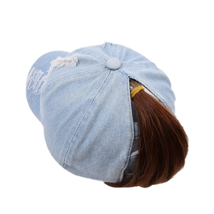 Light blue distressed denim ponytail baseball cap with ripped details and open back