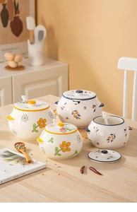 Detailed view of hand-painted daisy ceramic spice jars with integrated lid and spoon set