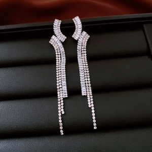 Detail of silver long tassel earrings with sparkling zircons on a black display box