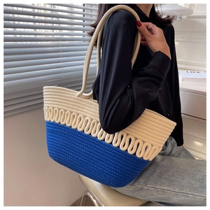 Detail of blue and beige woven tote bag showing thick cotton rope texture and strap
