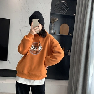 Detail of warm orange hooded sweatshirt featuring retro cartoon print and soft fabric texture