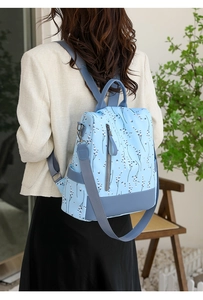 Détail d'un sac à dos floral bleu clair en nylon imperméable avec fermeture éclair antivol