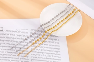 Detail of gold and silver hollow bead bracelets with lobster clasps on white plate