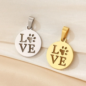 Detail of 18K gold and silver round pendants with LOVE lettering and paw print cutouts