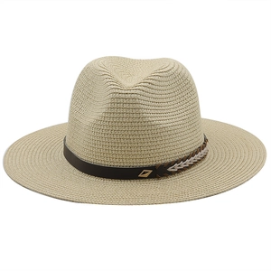 Close-up of beige straw fedora featuring a brown leather band and gold metal buckle