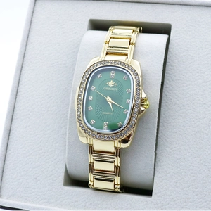 Elegant gold quartz watch with green oval dial and rhinestone bezel on a gray cushion