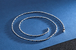 Gros plan d'une chaîne à billes en acier inoxydable argenté poli avec perles métalliques