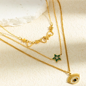 Gros plan détaillé du collier triple épaisseur en acier doré avec pendentifs mauvais œil