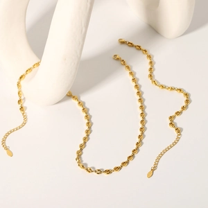 Detail of 18K gold-plated stainless steel coffee bean chain with lobster clasp and tag